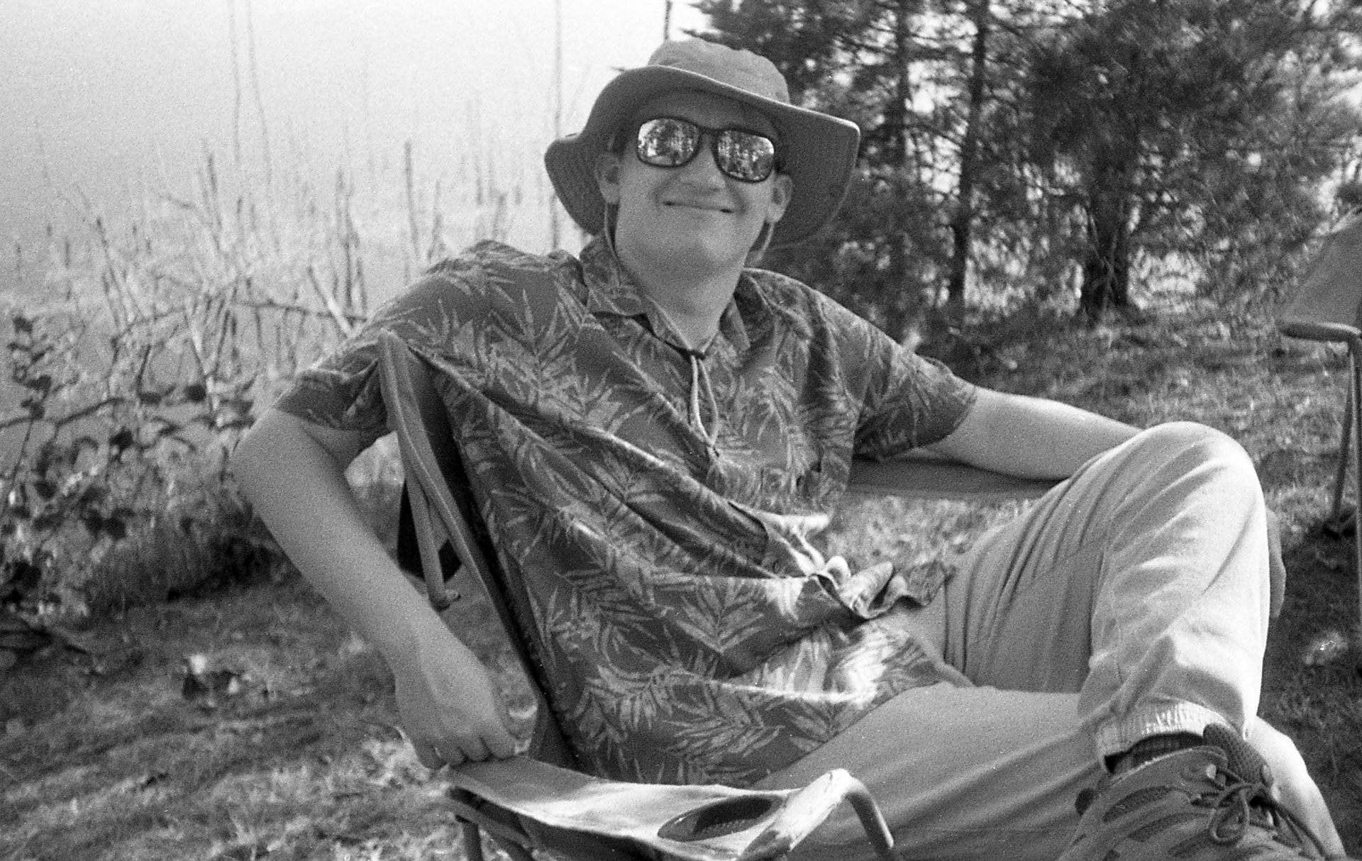 A man lounging in a tropical shirt