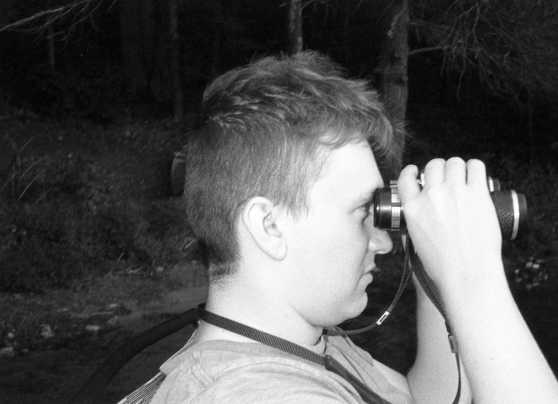 A man with binoculars looking off into the distance